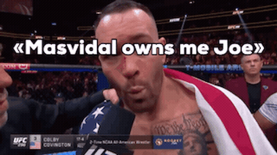 A Man With An American Flag Wrapped Around His Chest Is Being Interviewed By Colby Covington GIF