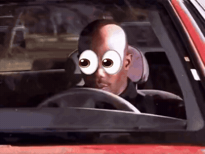A Man With Big Eyes Is Driving A Red Car . GIF