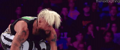 A Man With Blonde Hair And A Beard Is Kneeling Down In A Wrestling Match . GIF