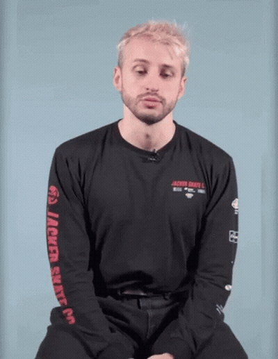A Man With Blonde Hair And A Beard Is Wearing A Black Shirt With The Word Jackie On The Front . GIF