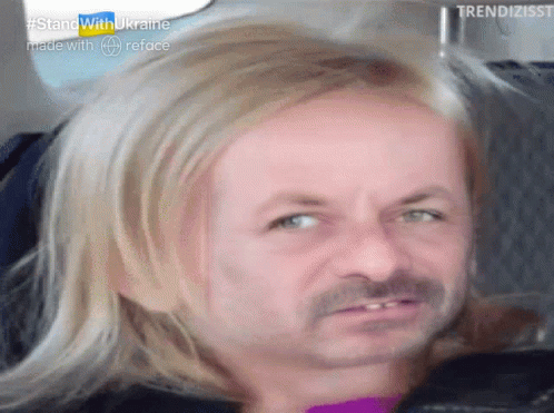 A Man With Blonde Hair And A Mustache Is Sitting In A Car . GIF