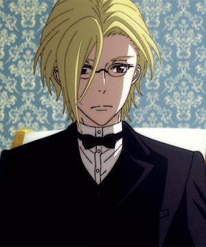 A Man With Blonde Hair And Glasses Is Wearing A Tuxedo GIF