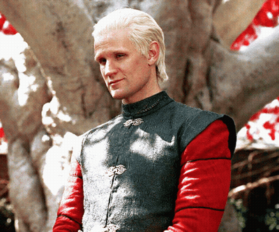 A Man With Blonde Hair And Red Sleeves Is Wearing A Green Vest GIF