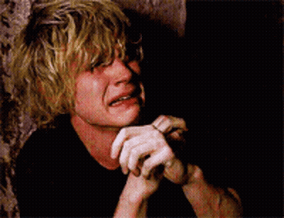 A Man With Blonde Hair Is Crying With His Hands On His Chin GIF