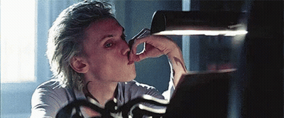 A Man With Blonde Hair Is Licking His Nose While Looking At A Mirror . GIF