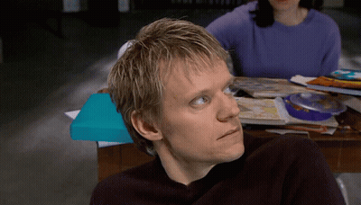 A Man With Blonde Hair Is Sitting At A Table With A Blue Box On It GIF