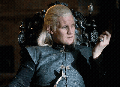 A Man With Blonde Hair Is Sitting In A Chair Holding A Sword GIF
