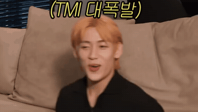 A Man With Blonde Hair Is Sitting On A Couch With A Foreign Language Written On The Bottom . GIF