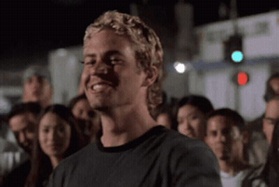 A Man With Blonde Hair Is Smiling In A Crowd Of People GIF