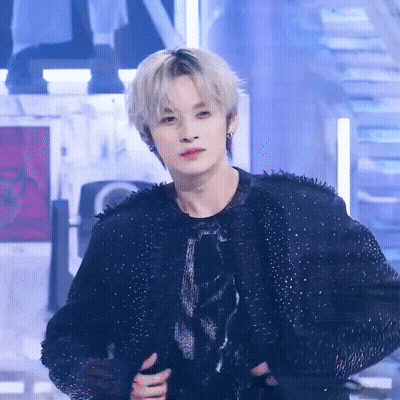 A Man With Blonde Hair Is Wearing A Black Jacket And A Black Shirt GIF