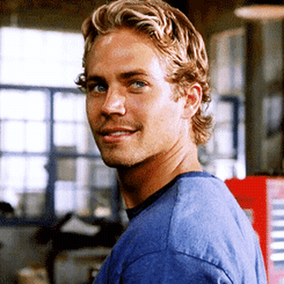 A Man With Blonde Hair Is Wearing A Blue Shirt And Looking At The Camera GIF