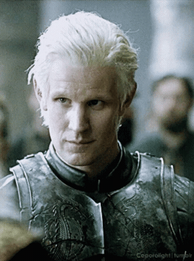 a man with blonde hair is wearing a knight 's armor and is looking at the camera