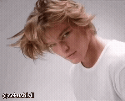A Man With Blonde Hair Is Wearing A White T-Shirt With The Hashtag @Sekushivii GIF