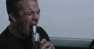 A Man With Blood On His Face Is Biting A Gun In His Mouth . GIF