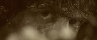 A Man With Blood On His Face Is Holding An Arrow GIF
