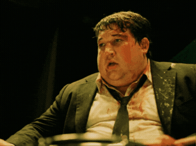 A Man With Blood On His Face Is Wearing A Black Suit And Tie GIF