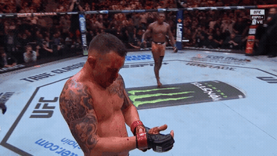 A Man With Blood On His Face Stands In A Ufc Boxing Ring GIF