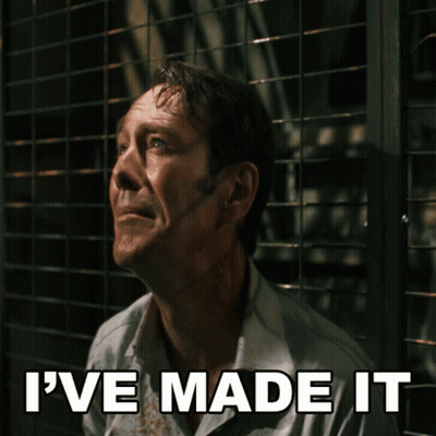 A Man With Blood On His Shirt Is Behind A Fence With The Words I 'Ve Made It Above Him GIF