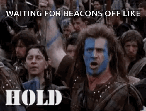A Man With Blue And White Paint On His Face Is Standing In Front Of A Crowd Of People Holding Up Their Arms . GIF