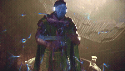 A Man With Blue Eyes And A Scarf Around His Neck Is Standing In A Dark Room GIF