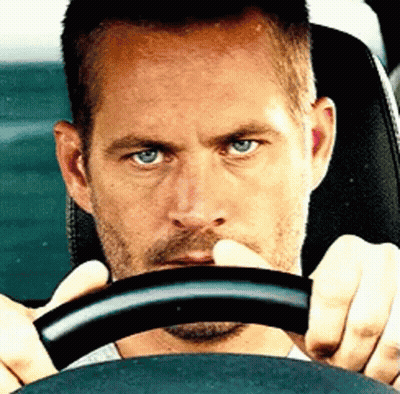 A Man With Blue Eyes Is Holding The Steering Wheel GIF
