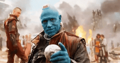 A Man With Blue Hair And A Beard Is Holding A Skull . GIF