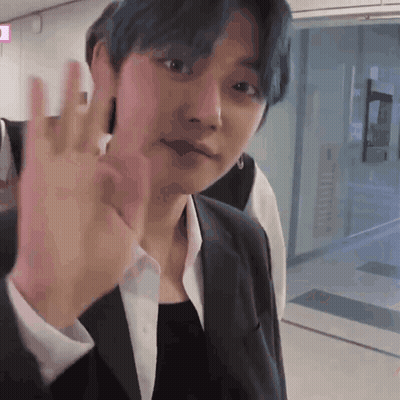 A Man With Blue Hair Is Waving His Hand GIF