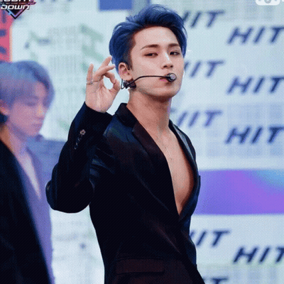 A Man With Blue Hair Is Wearing A Black Jacket And A Microphone GIF