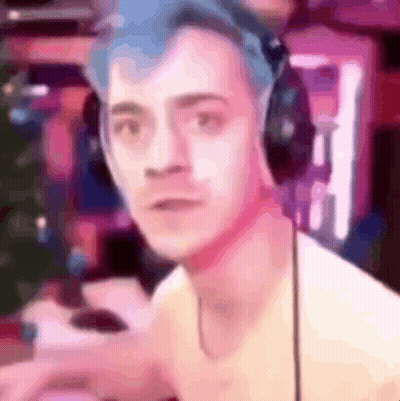 A Man With Blue Hair Is Wearing Headphones And Looking At The Camera In A Blurry Photo . GIF