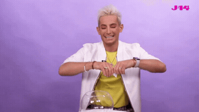 A Man With Braces On His Teeth Is Laughing In Front Of A Purple Background With The Letters J-14 On It GIF
