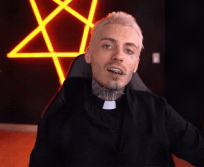 A Man With Braces On His Teeth Is Sitting In A Chair In Front Of A Neon Pentagram . GIF