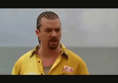 A Man With Braids And A Beard Is Wearing A Yellow Shirt GIF