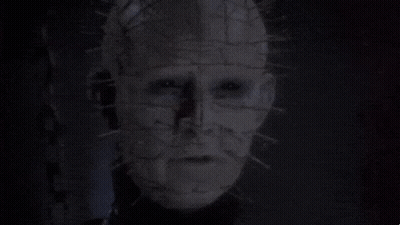 A Man With Chains Around His Neck Is Looking At The Camera GIF
