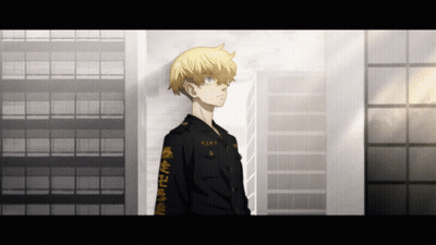 A Man With Chinese Writing On His Sleeve Stands In Front Of A Tall Building GIF