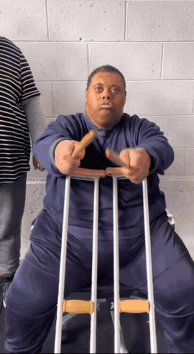 A Man With Crutches Is Holding A French Fry GIF