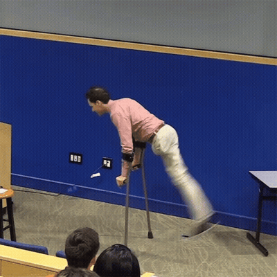 A Man With Crutches Is Standing In Front Of A Blue Wall With A Few Electrical Outlets On It GIF