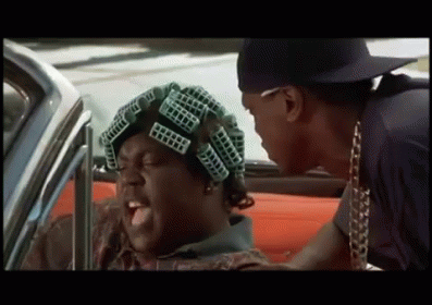 A Man With Curlers On His Head Is Talking To Another Man GIF