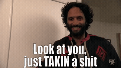A Man With Curly Hair And A Beard Is Smiling And Saying Look At You Just Takin A Shit GIF