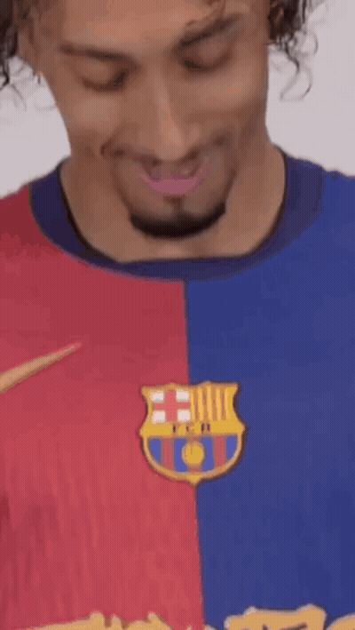 A Man With Curly Hair And A Beard Is Wearing A Barcelona Shirt . GIF