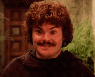 A Man With Curly Hair And A Mustache Is Smiling At The Camera . GIF