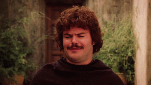 A Man With Curly Hair And A Mustache Making A Face GIF