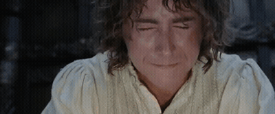 A Man With Curly Hair Is Crying With His Eyes Closed And His Mouth Open . GIF