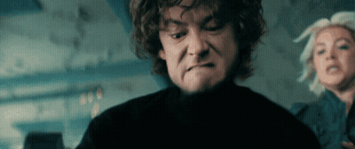 A Man With Curly Hair Is Making A Face While A Woman Looks On GIF