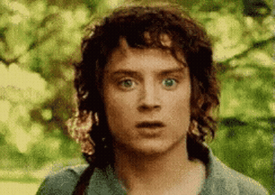 A Man With Curly Hair Is Making A Surprised Face . GIF