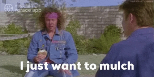 A Man With Curly Hair Is Sitting In The Grass Talking To Another Man While Holding An Ice Cream Cone . GIF