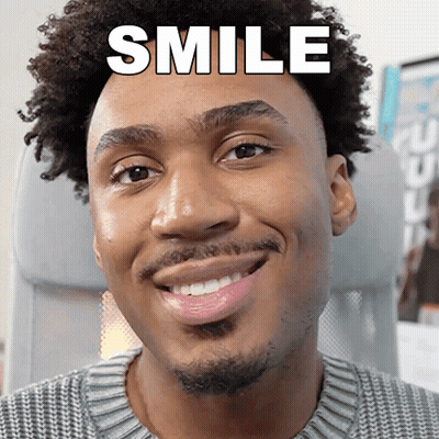 A Man With Curly Hair Is Smiling With The Word Smile Above His Head GIF