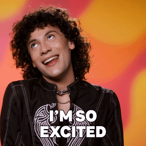 A Man With Curly Hair Is Smiling With The Words I 'M So Excited Behind Him GIF