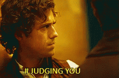 A Man With Curly Hair Is Talking To Another Man And Says # Judging You . GIF