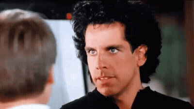 A Man With Curly Hair Is Talking To Another Man In A Movie . GIF