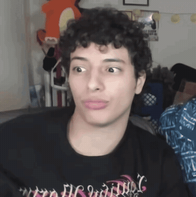 A Man With Curly Hair Is Wearing A Black Shirt That Says ' Nightmare ' GIF